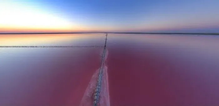 Framed Print : Top view of a shiny salty pink lake and a path along it Framed Print : Top view of a shiny salty pink lake and a path along it