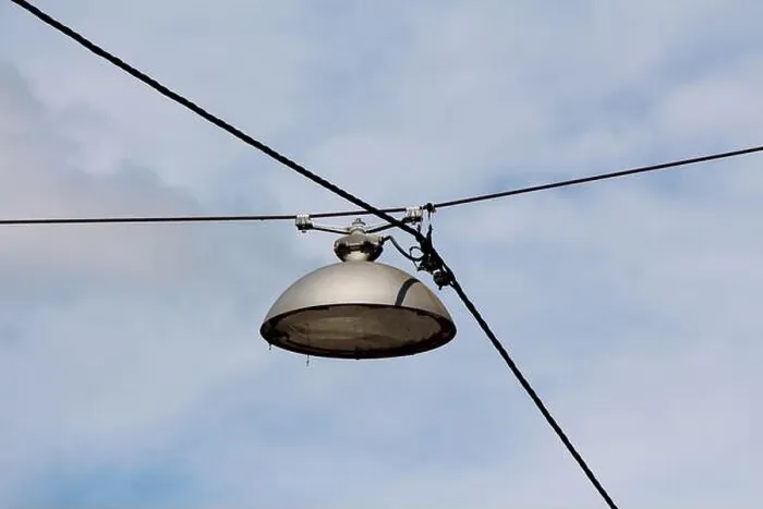 Framed Print : Side view of vintage retro old style large round street lamp within strong metal casing suspended with dark electrical Framed Print : Side view of vintage retro old style large round street lamp within strong metal casing suspended with dark electrical