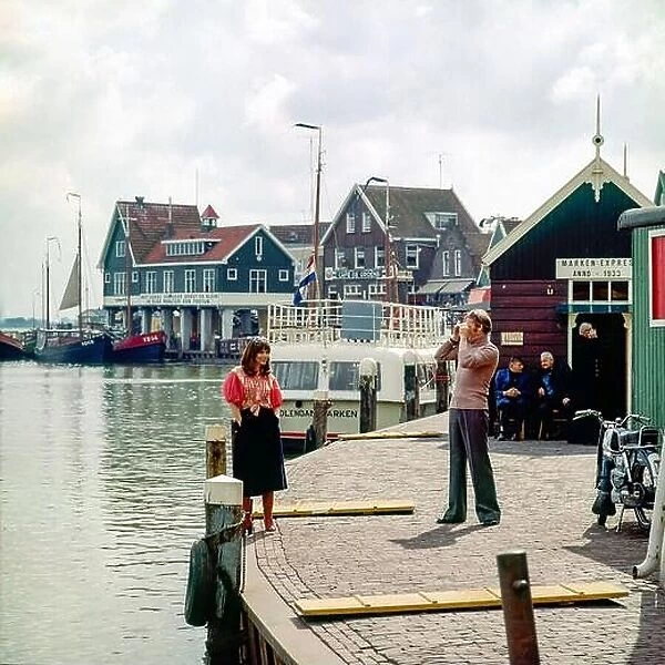 Vintage Netherlands 1970s, couple of middle aged tourists taking pictures, Marken harbour, Waterland, Northern Holland, Europe