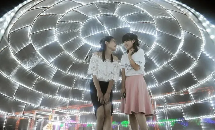 Framed Print : Visitors talk under an installation of LED lights during a light art festival at Huahai Park in Taiyuan city