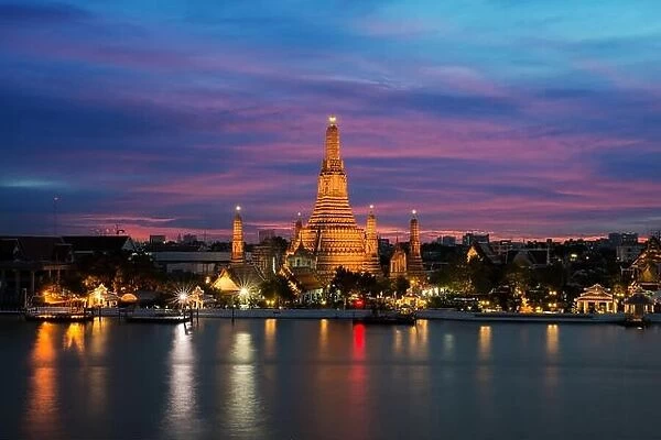 Wat Arun temple and Chao Phraya River at night in Bangkok, Thailand