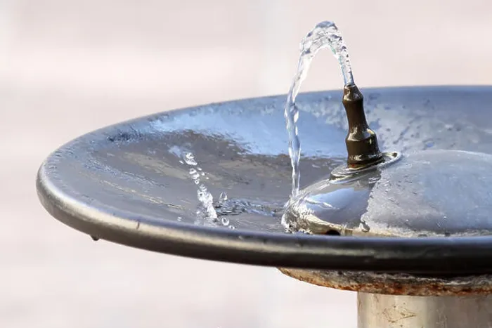 Framed Print : Water flowing from a faucet in a public fountain and falling into a plate Framed Print : Water flowing from a faucet in a public fountain and falling into a plate