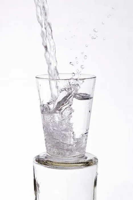 Framed Print : Water vigorously poured overflowing splashing from a glass, on a white background Framed Print : Water vigorously poured overflowing splashing from a glass, on a white background