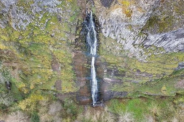 A waterfall flows over a cliff into the Columbia River Gorge in Oregon. This canyon, with the Columbia River flowing through it, is 80 miles long