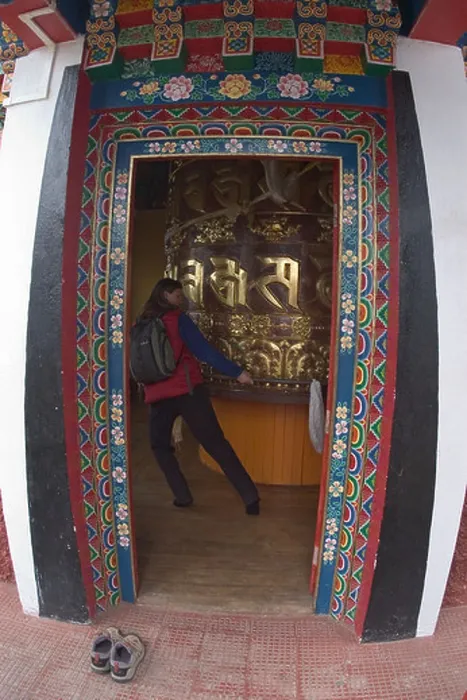 Framed Print : Wende Valentine spins a massive prayer wheel at the Tibetan Buddhist monastery of Pemayangtse near the village of