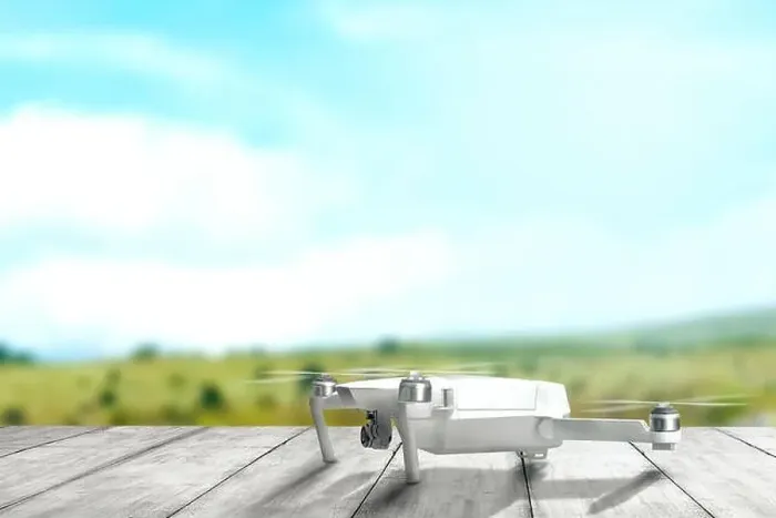 Framed Print : White drone with camera on wooden table ready to flying to the air with blurry landscapes background Framed Print : White drone with camera on wooden table ready to flying to the air with blurry landscapes background