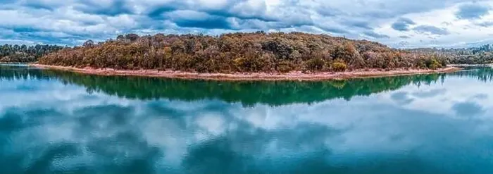Framed Print : Wide beautiful panorama of trees growing on lakeshore with scenic clouds reflections in the water Framed Print : Wide beautiful panorama of trees growing on lakeshore with scenic clouds reflections in the water