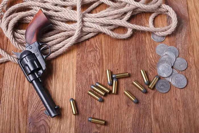 Framed Print : Wild west gun, ammunition and silver dollars on wooden table Framed Print : Wild west gun, ammunition and silver dollars on wooden table