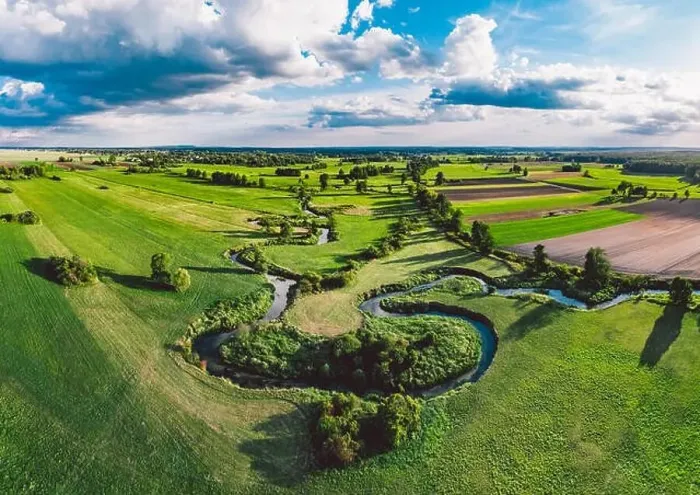 Framed Print : A winding river surrounded by green meadows Framed Print : A winding river surrounded by green meadows