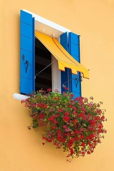 Window with blue shutter and red flowers, Burano Island near Venice, Italy