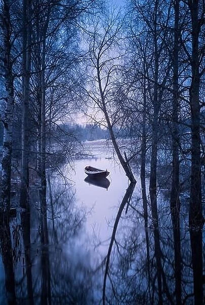 Winter landscape with sunset and boat at evening in Finland