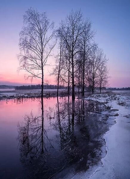 Winter landscape with sunset and smooth river at evening in Finland