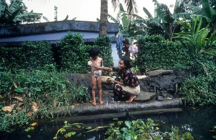 Framed Print : A Woman Bathing her daughter, Backwaters of kerala. Mother & child Framed Print : A Woman Bathing her daughter, Backwaters of kerala. Mother & child
