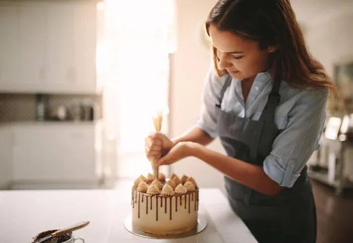 Framed Print : Woman decorating chocolate cake in the kitchen. Female chef making a cake at home Framed Print : Woman decorating chocolate cake in the kitchen. Female chef making a cake at home