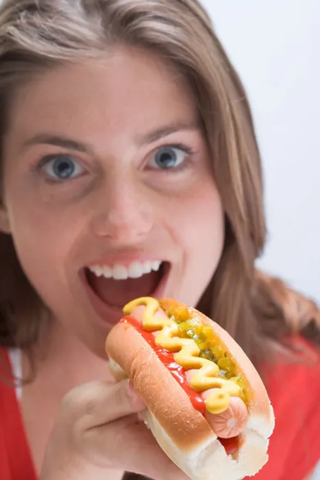 Framed Print : Woman eating a hot dog with mustard - Framed Print : Woman eating a hot dog with mustard -