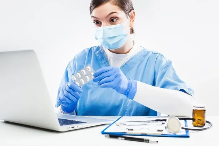 Framed Print : Woman GP doctor holding medicine prescribing patient therapy during online virtual appointment over laptop computer Framed Print : Woman GP doctor holding medicine prescribing patient therapy during online virtual appointment over laptop computer