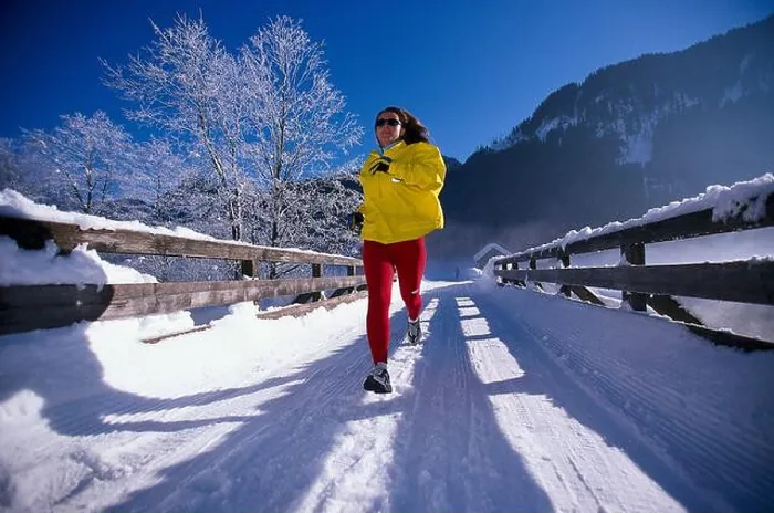 Framed Print : Woman jogging on snow covered track under blue sky Framed Print : Woman jogging on snow covered track under blue sky