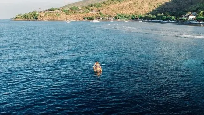 Framed Print : Woman kayaking in ocean on kayak near coastline. Drone view Framed Print : Woman kayaking in ocean on kayak near coastline. Drone view