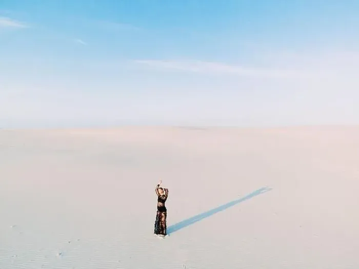 Framed Print : Woman in lace black dress stands in desert and casts a shadow on white sand. View from drone Framed Print : Woman in lace black dress stands in desert and casts a shadow on white sand. View from drone