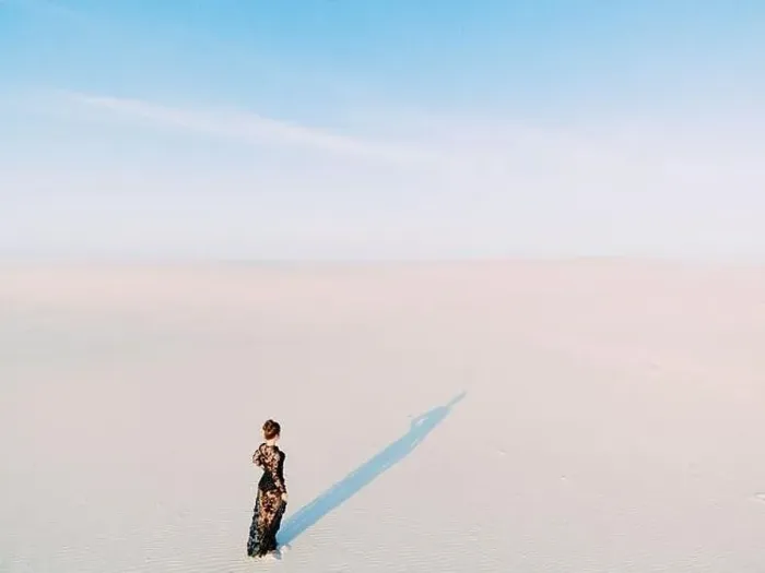 Framed Print : Woman in lace black dress walks in desert and casts a shadow on white sand. View from drone Framed Print : Woman in lace black dress walks in desert and casts a shadow on white sand. View from drone