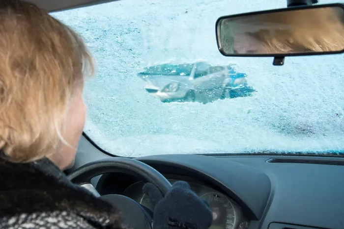 Framed Print : Woman is looking in a car through a small scratched gap in an icy windshield Framed Print : Woman is looking in a car through a small scratched gap in an icy windshield