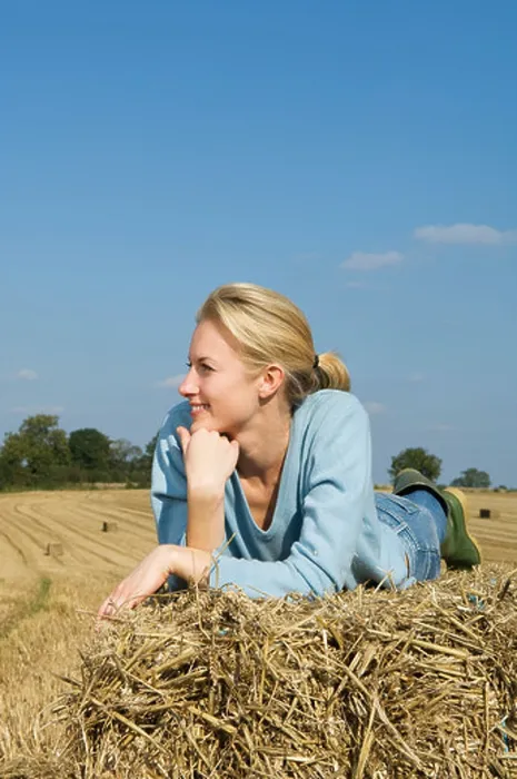 Framed Print : Woman lying on hay bale Framed Print : Woman lying on hay bale