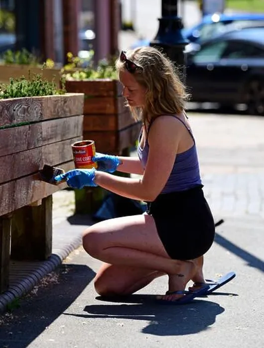 Framed Print : Woman painting flower bed box outside her shop during Coronavirus (COVID-19) pandemic, Haslemere, Surrey, UK