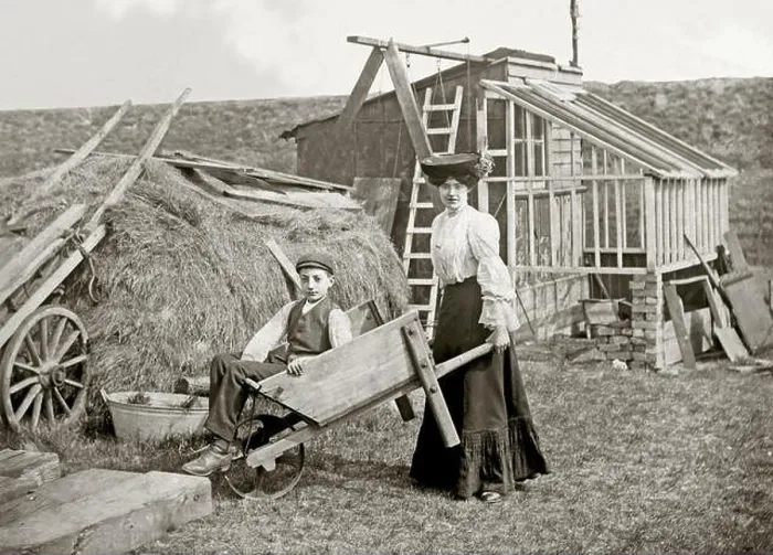 Framed Print : A woman pushing a man in a wheelbarrow Framed Print : A woman pushing a man in a wheelbarrow
