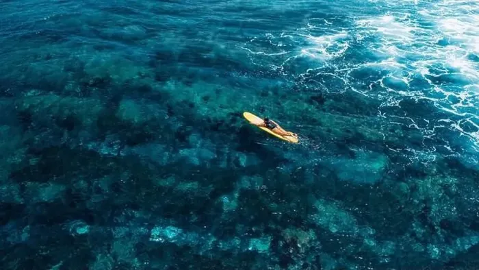 Framed Print : Woman rowing on surfboard in blue ocean. Drone view of woman during surfing Framed Print : Woman rowing on surfboard in blue ocean. Drone view of woman during surfing
