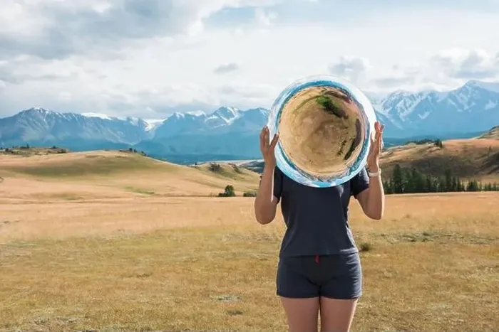 Framed Print : Woman standing in in summer Altai mountains in Kurai steppe and holding circle mirror Framed Print : Woman standing in in summer Altai mountains in Kurai steppe and holding circle mirror