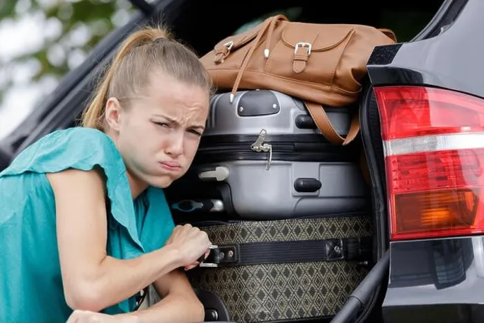 Framed Print : woman struggling to fix luggage in a car Framed Print : woman struggling to fix luggage in a car