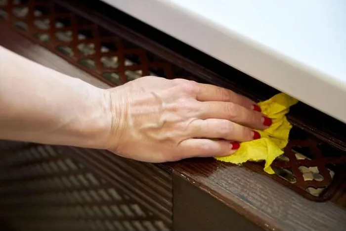 Framed Print : Woman wipes a window sill with a damp yellow rag Framed Print : Woman wipes a window sill with a damp yellow rag