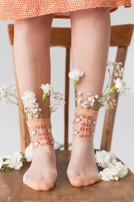 Framed Print : Woman's legs with white flowers in socks standing on chair Framed Print : Woman's legs with white flowers in socks standing on chair