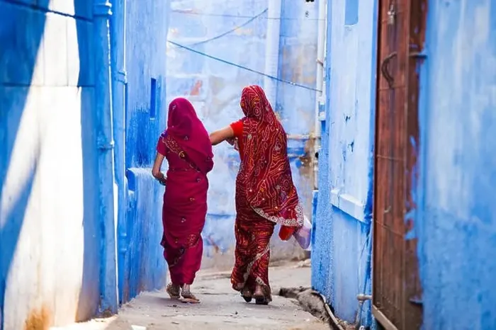 Framed Print : Two women dressed in the traditional Indian Saree are walking through the narrow streets of the blue city of Jodhpur Framed Print : Two women dressed in the traditional Indian Saree are walking through the narrow streets of the blue city of Jodhpur