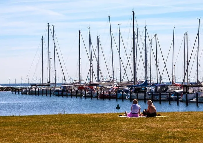 Framed Print : Two women sit and admire moored yachts at Dragør fishing village near Copenhagen in Denmark with wind farm in background Framed Print : Two women sit and admire moored yachts at Dragør fishing village near Copenhagen in Denmark with wind farm in background