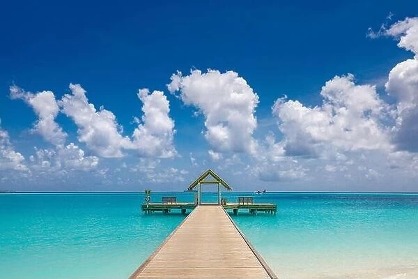 Wooden bridge, jetty at tropical beach in the Maldives at sunny summer day. Amazing summer tropical island beach