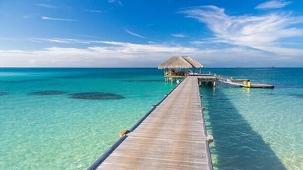 Wooden jetty over the beautiful Maldivian sea with blue sky. tranquil travel landscape, seascape. Maldives islands