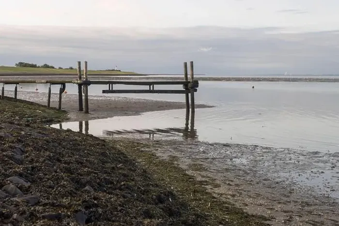 Framed Print : A wooden pier stretches over the tidal flats at low tide in the Wadden Sea Framed Print : A wooden pier stretches over the tidal flats at low tide in the Wadden Sea