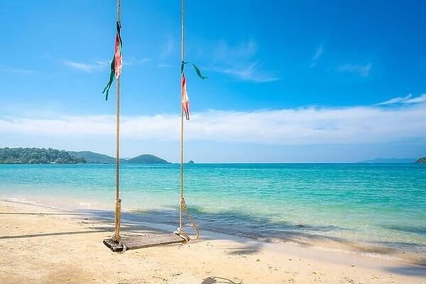 Wooden swing hanging on the palm tree with clear day sky in Koh Kood at Trat, Thailand. Summer, Travel, Vacation and Holiday. Relax and traveling at s