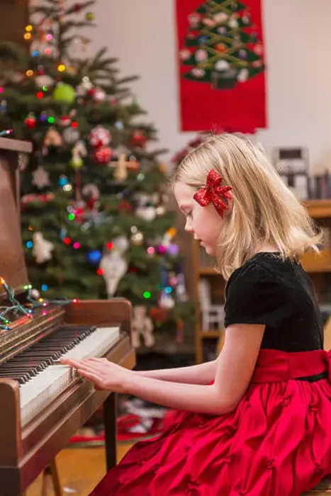Framed Print : Six Year Old Girl Wearing A Formal Dress, Red Bow In Her Hair, Playing The Piano, Christmas Tree In The Background Framed Print : Six Year Old Girl Wearing A Formal Dress, Red Bow In Her Hair, Playing The Piano, Christmas Tree In The Background