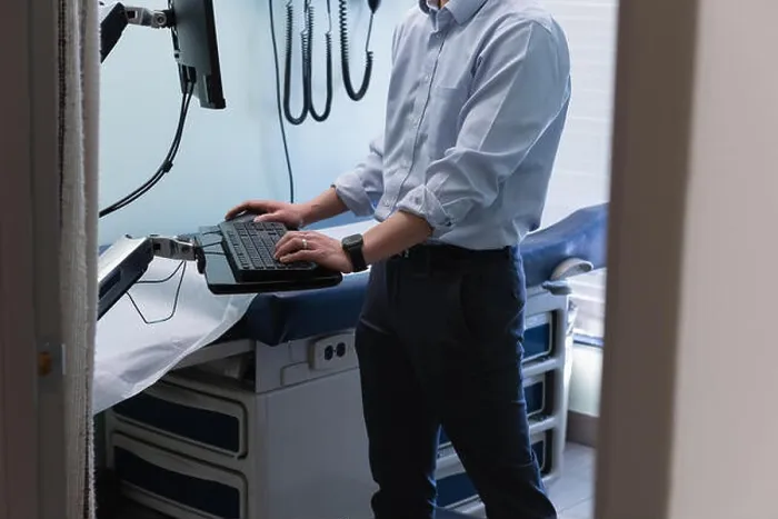 Framed Print : Young asian male doctor working on computer in clinic Framed Print : Young asian male doctor working on computer in clinic