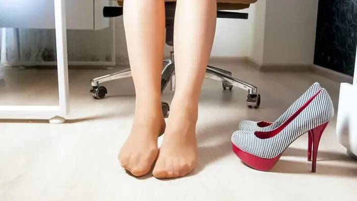 Framed Print : Young barefoot woman relaxing after wearing high heels shoes in office Framed Print : Young barefoot woman relaxing after wearing high heels shoes in office