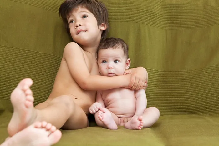 Framed Print : A young boy and his baby brother lying on the couch Framed Print : A young boy and his baby brother lying on the couch