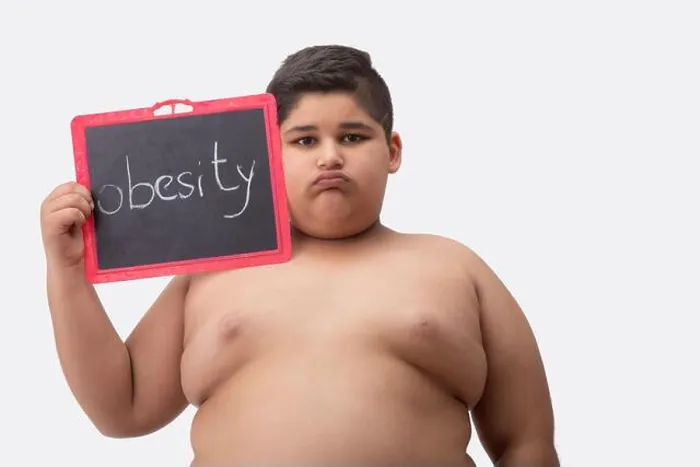 Framed Print : Young boy bare chested holding a small blackboard with obesity written on it Framed Print : Young boy bare chested holding a small blackboard with obesity written on it