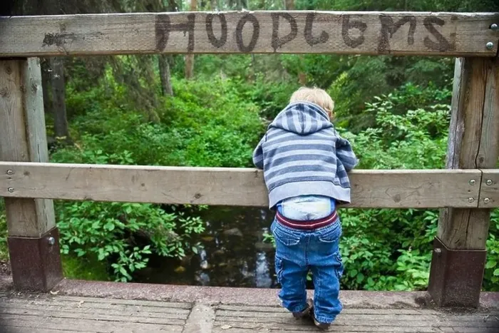 Framed Print : Young Boy Looking Over A Bridge With His Pants Falling Down And The Sign Hoodlums Over His Head Framed Print : Young Boy Looking Over A Bridge With His Pants Falling Down And The Sign Hoodlums Over His Head