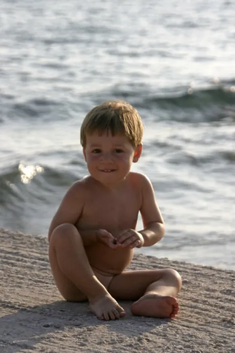 Framed Print : Young boy naked nude or bare sitting by the sea in Saronida Greece Framed Print : Young boy naked nude or bare sitting by the sea in Saronida Greece