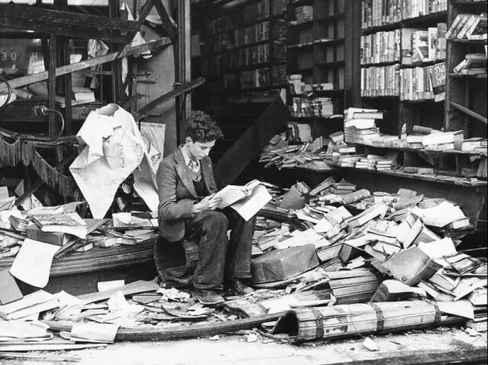 Framed Print : A young boy sat reading outside the ruins of a London bookshop after an air raid during the Blitz, London 1940 Framed Print : A young boy sat reading outside the ruins of a London bookshop after an air raid during the Blitz, London 1940