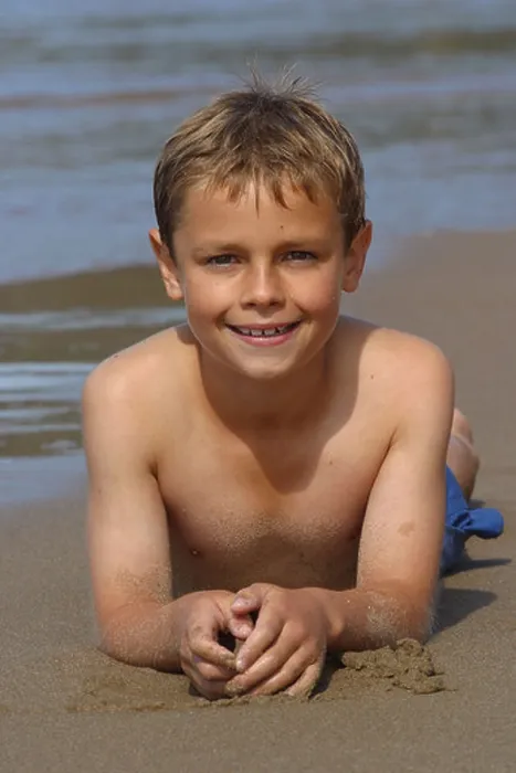 Framed Print : Young boy white caucasian aged 10 years old lying on sand beach sea shoreline Framed Print : Young boy white caucasian aged 10 years old lying on sand beach sea shoreline