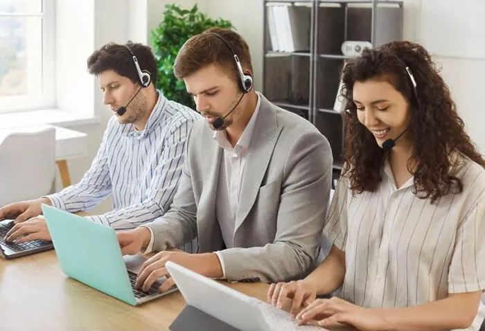 Framed Print : Young business people sitting in a row working in call center at online support service office Framed Print : Young business people sitting in a row working in call center at online support service office