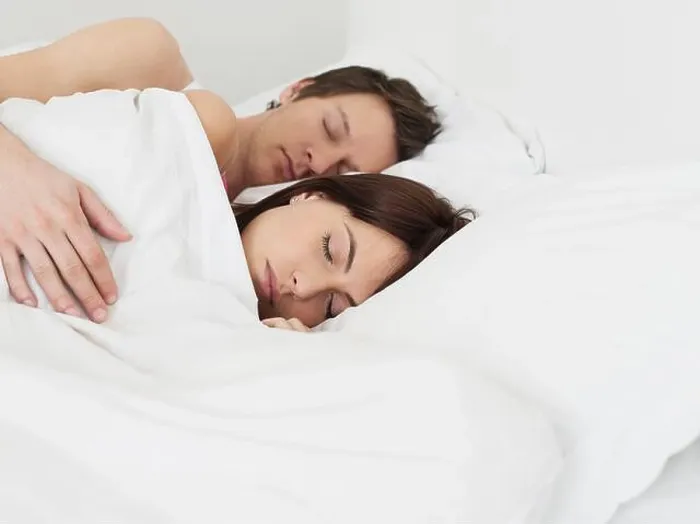 Framed Print : Young couple sleeping in bed man's arm around woman Framed Print : Young couple sleeping in bed man's arm around woman